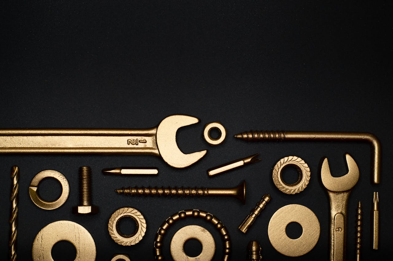 Artistic arrangement of gold tools on a black background, offering ample copy space.